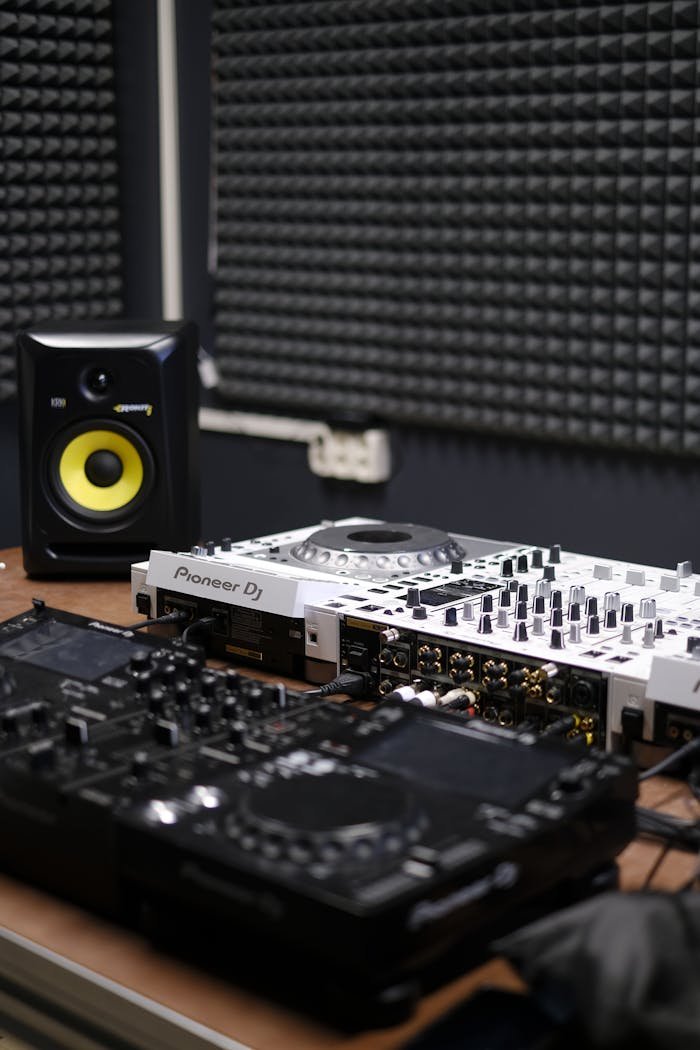 High-quality DJ mixer and speaker setup in a modern music studio with soundproofing.
